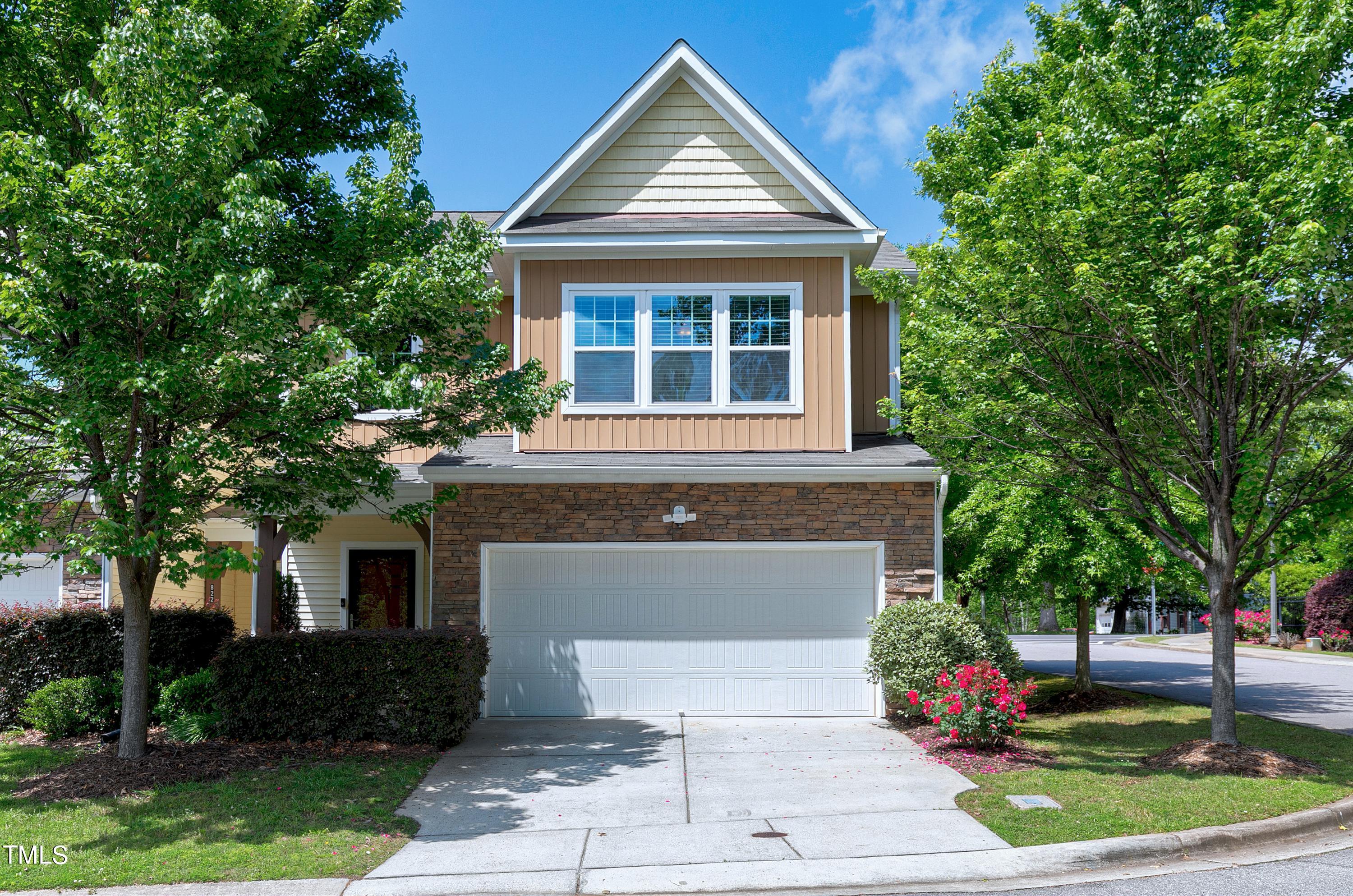 a front view of a house with a yard and trees