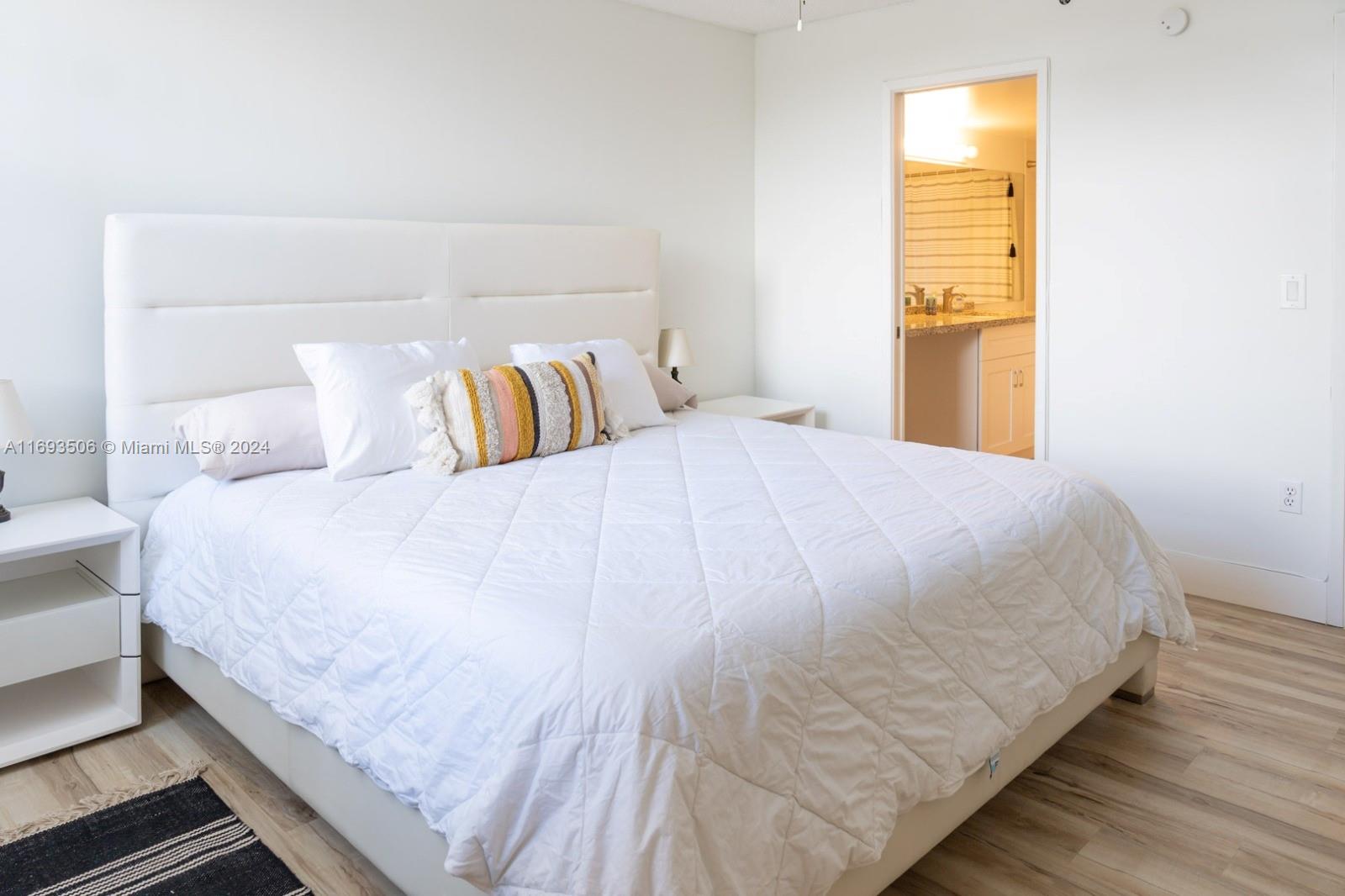 a large bed sitting in a bedroom next to a window