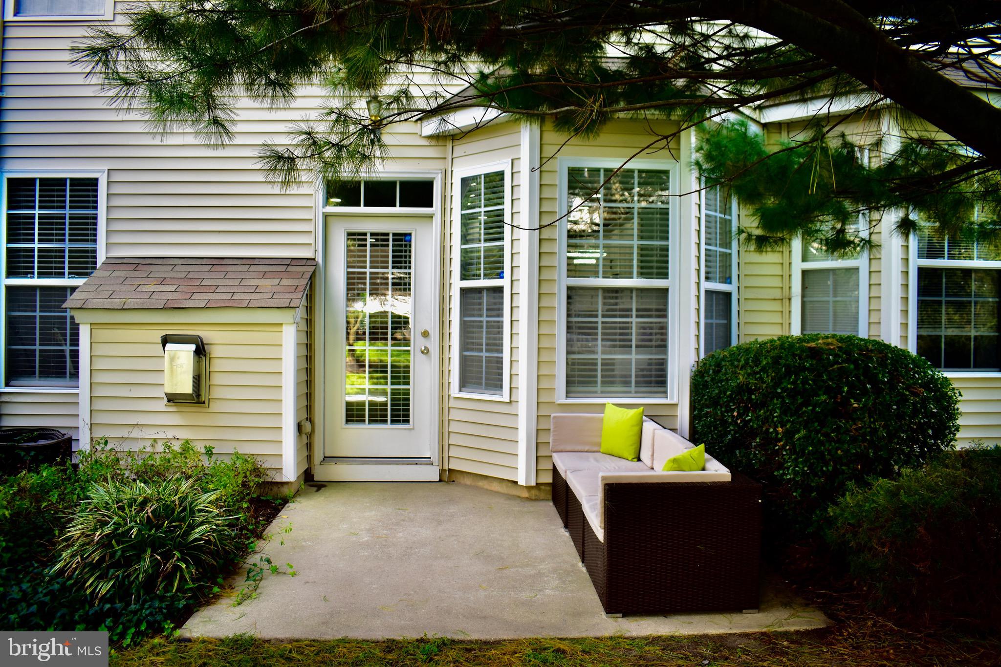 a view of a house with a large window and flower plants