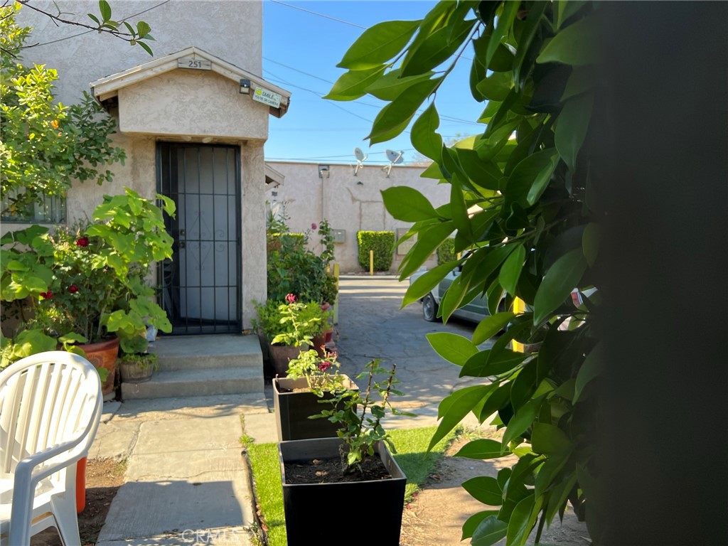 a backyard of a house with a fountain plants and flowers