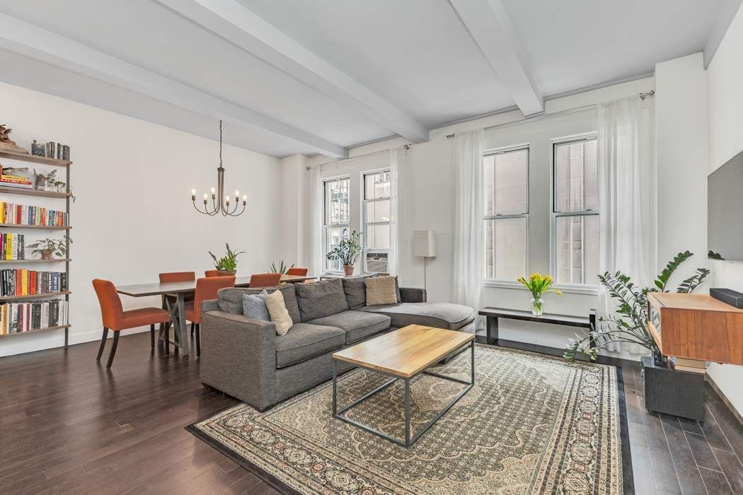 a living room with furniture wooden floor and a window