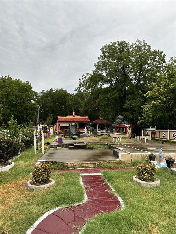 a front view of a house with garden and trees