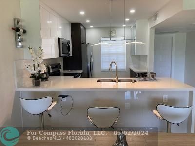 a kitchen with kitchen island stainless steel appliances a sink and a refrigerator