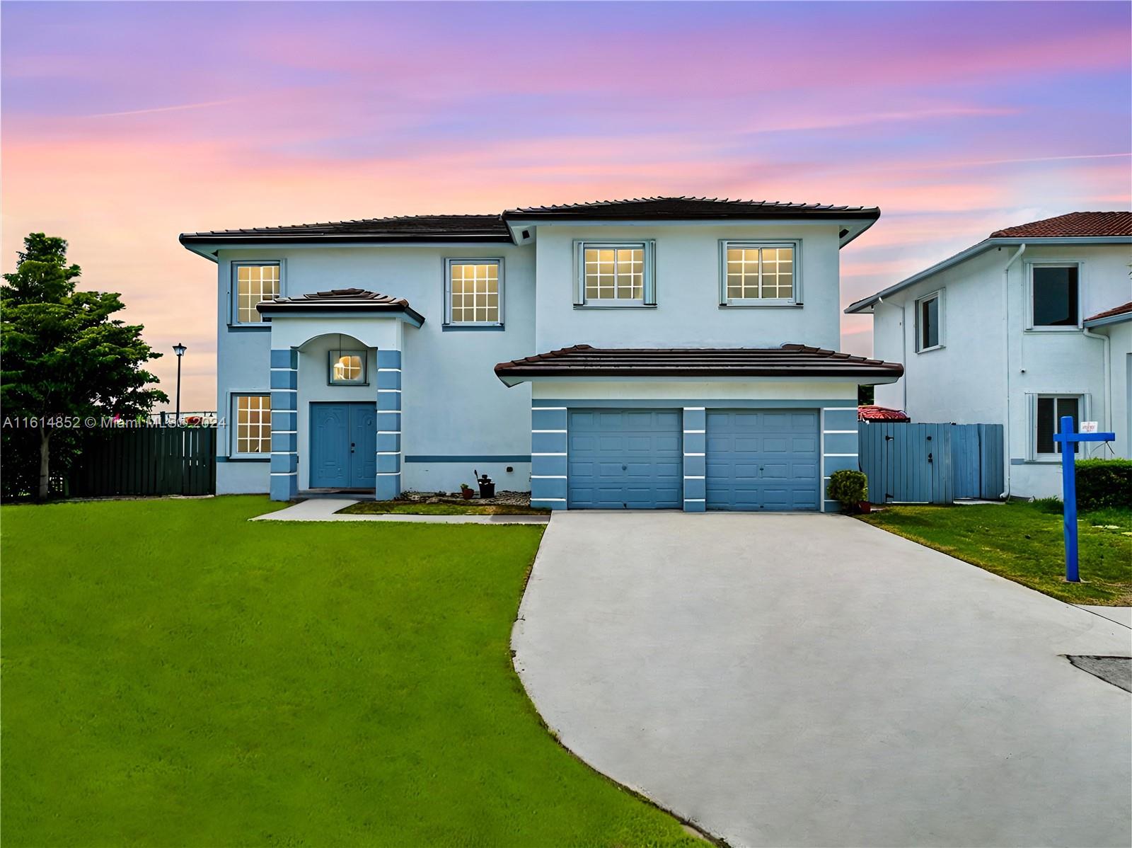 a front view of a house with a yard and garage