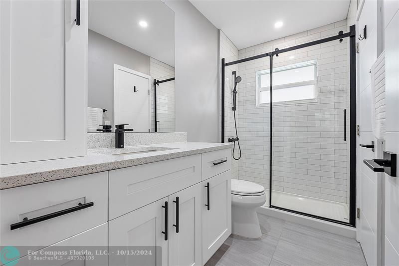 a bathroom with a double vanity sink toilet and shower