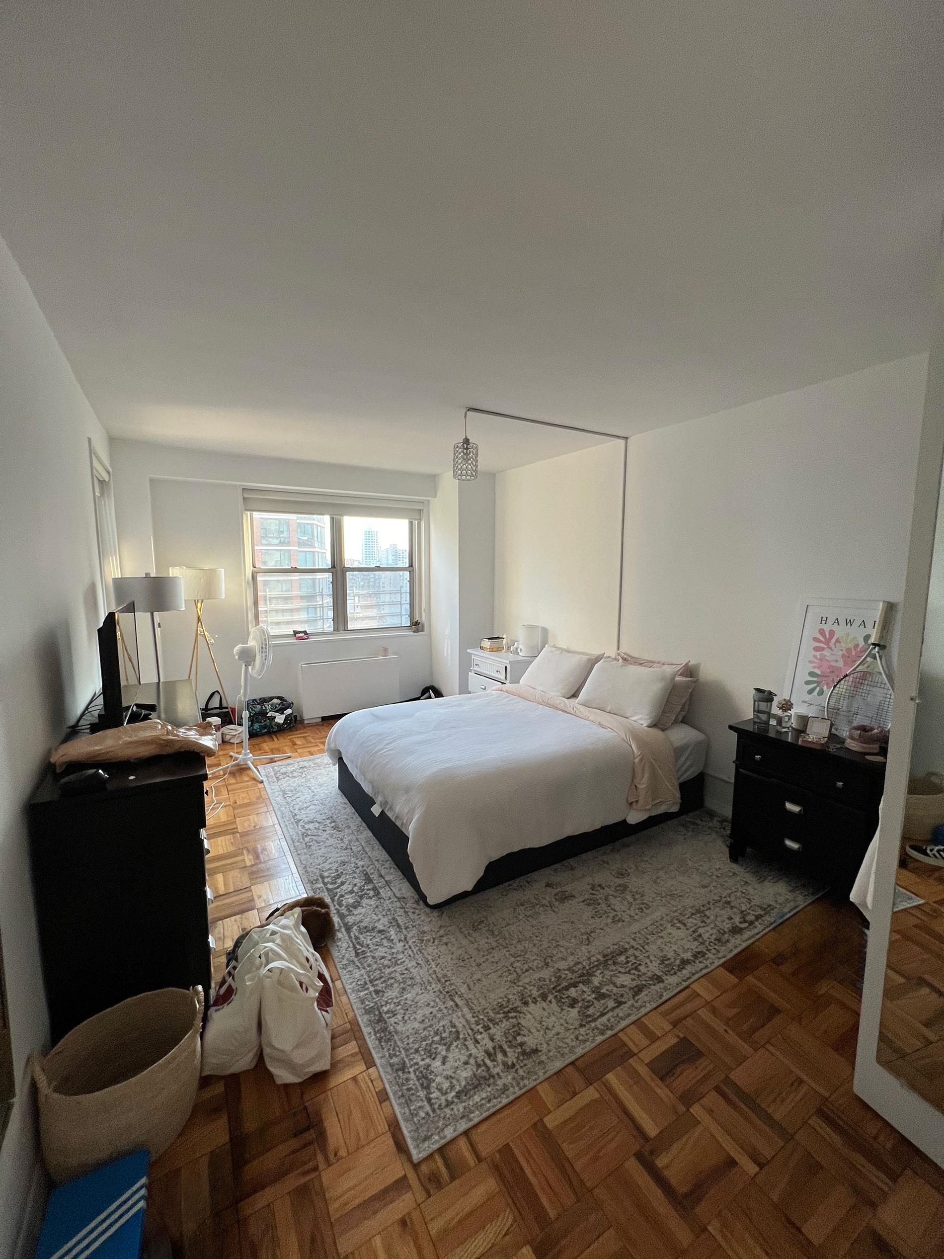 a bedroom with a bed and dresser with mirror