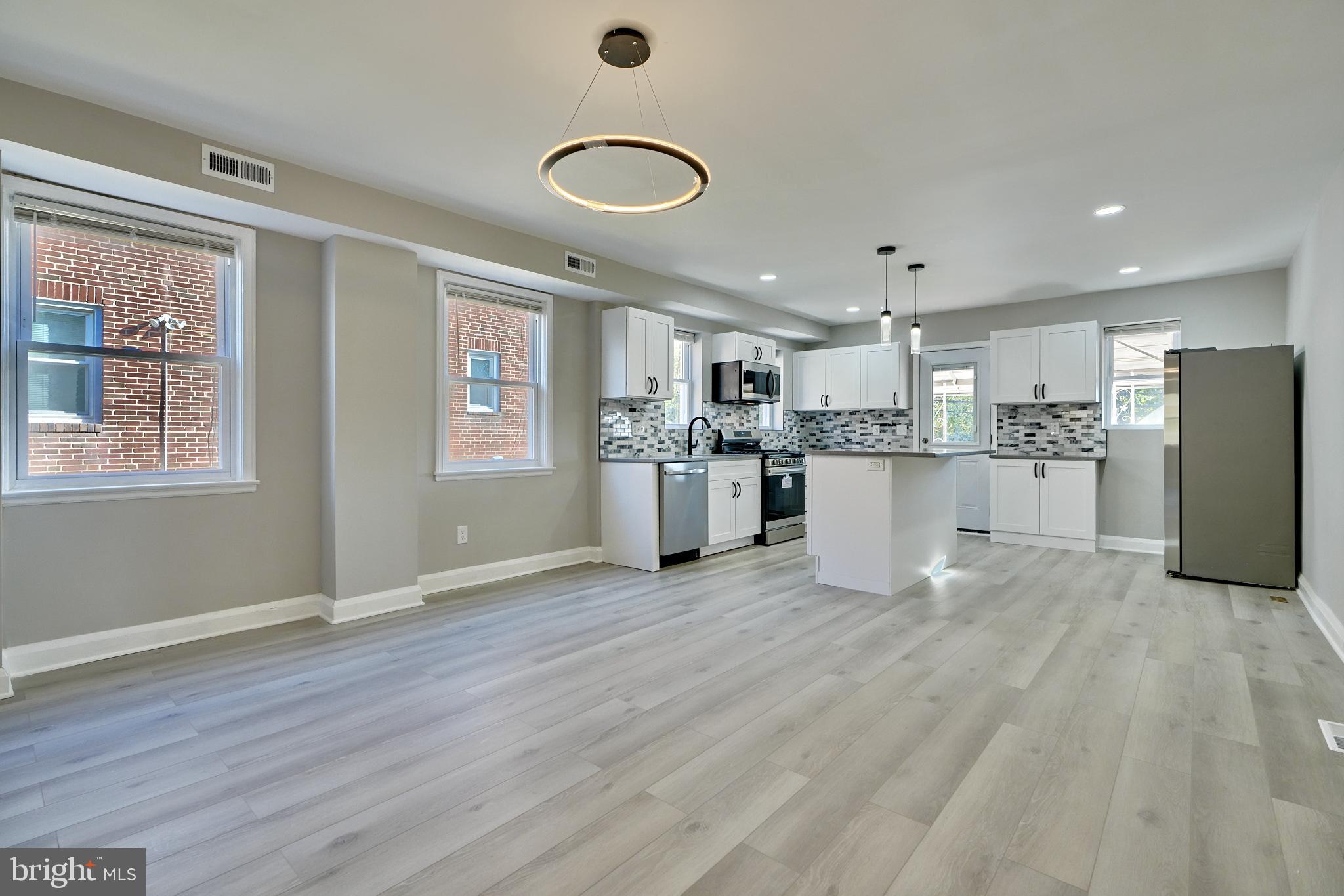 a view of a kitchen with stainless steel appliances granite countertop a refrigerator and a stove top oven