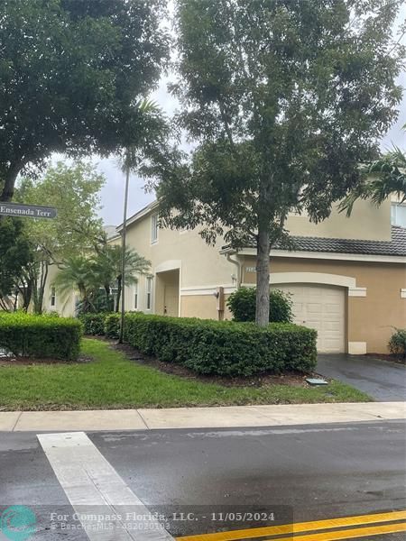 a front view of a house with a yard and a garage