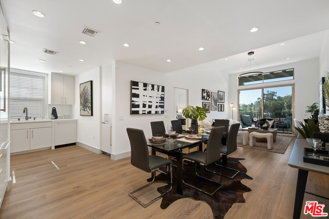 a living room with furniture potted plant wooden floor and a large window