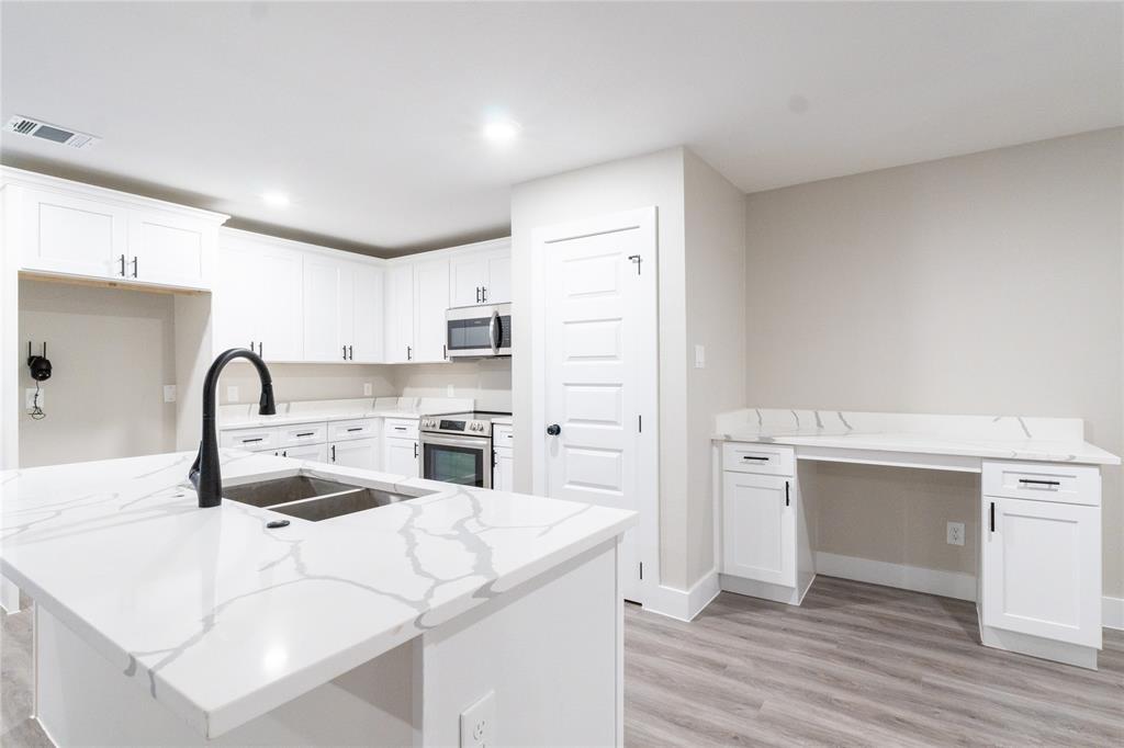 a kitchen with a sink cabinets and wooden floor