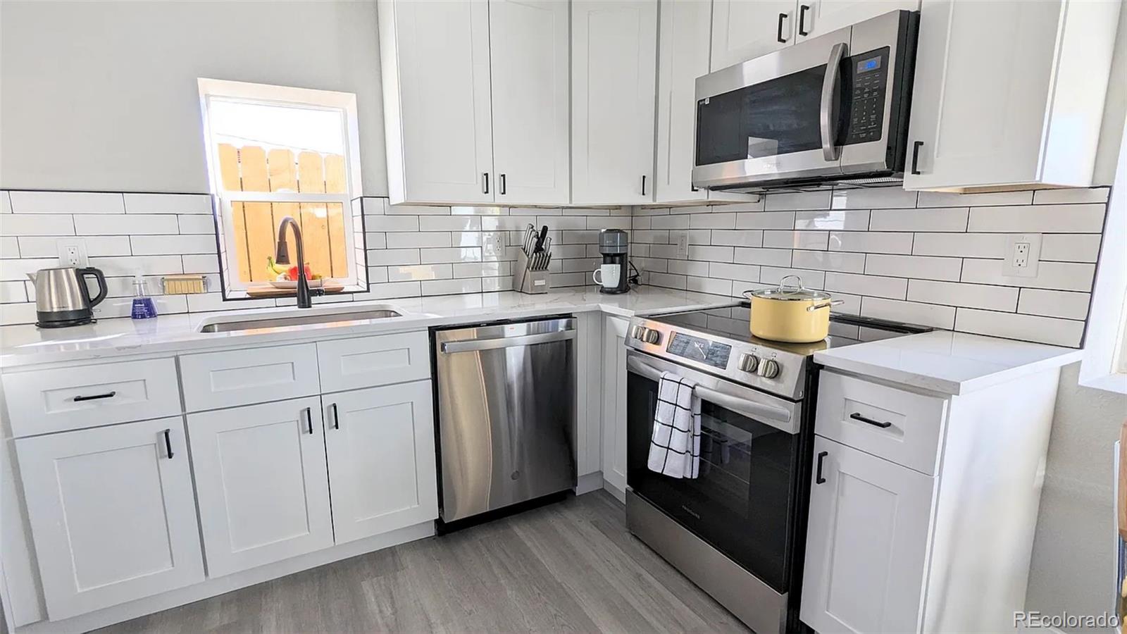 a kitchen with stainless steel appliances a sink a stove and microwave