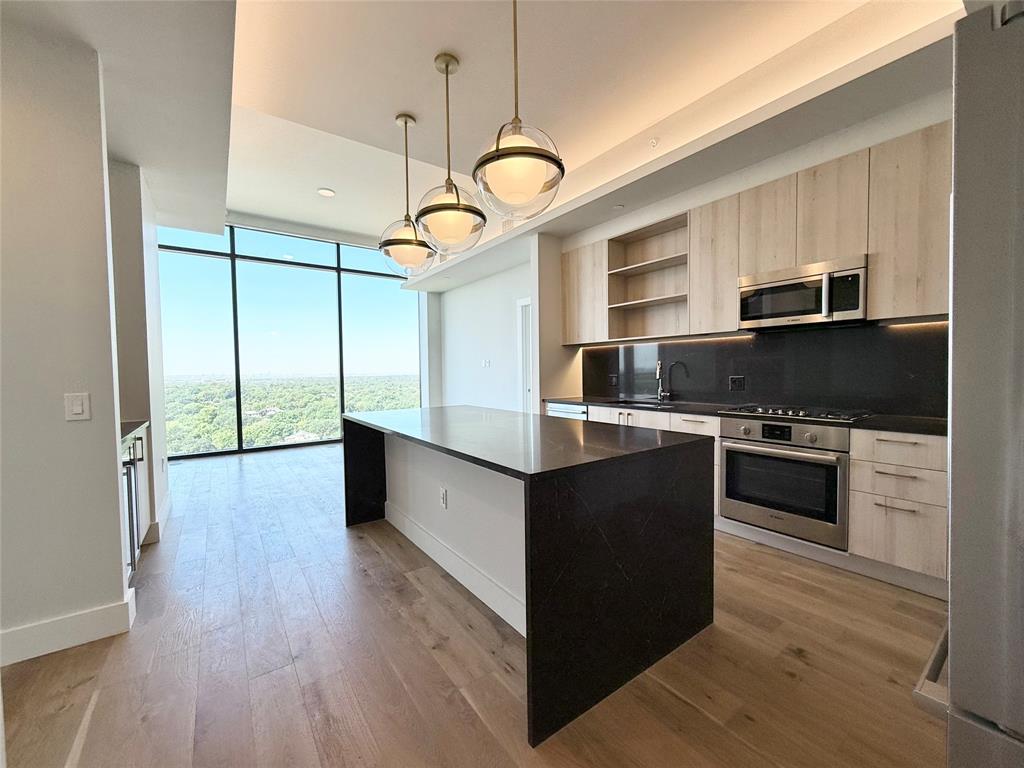 a kitchen with stainless steel appliances granite countertop a stove and a refrigerator