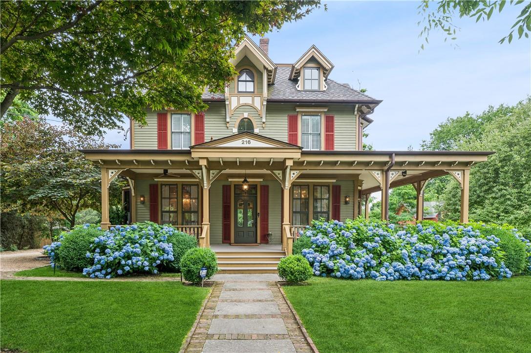 Victorian home with lovely wraparound verandas and lush front lawn