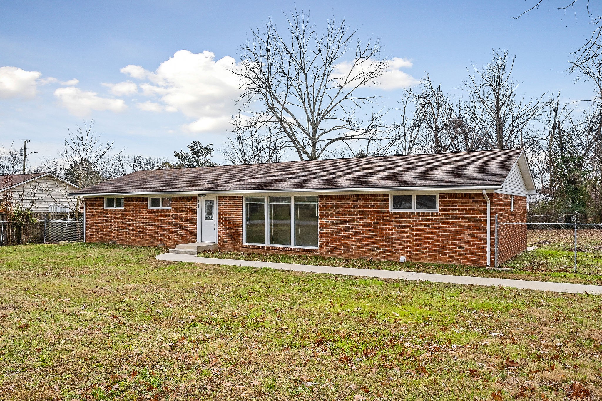 a front view of a house with a garden and yard