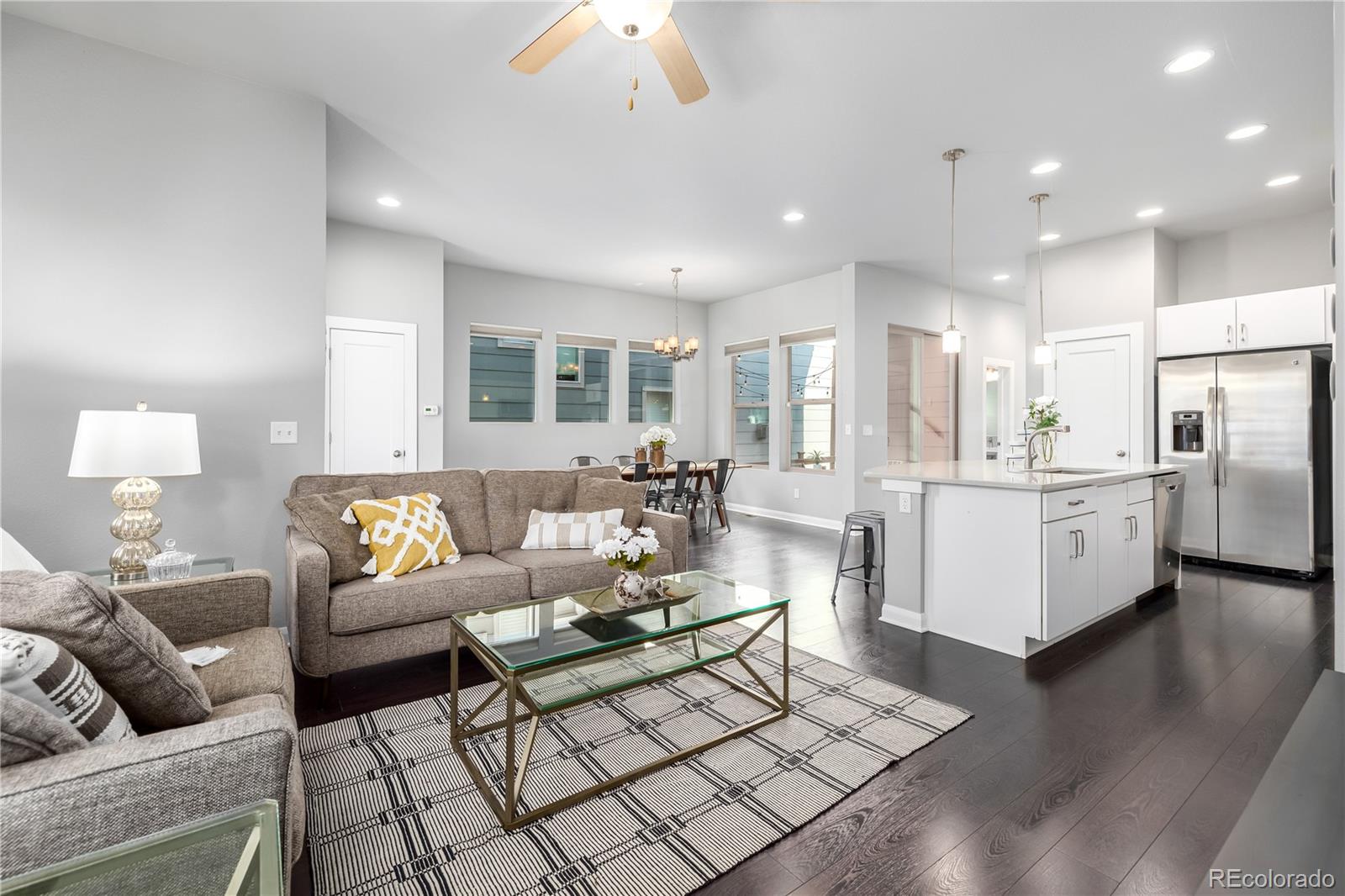 a living room with furniture kitchen view and a chandelier