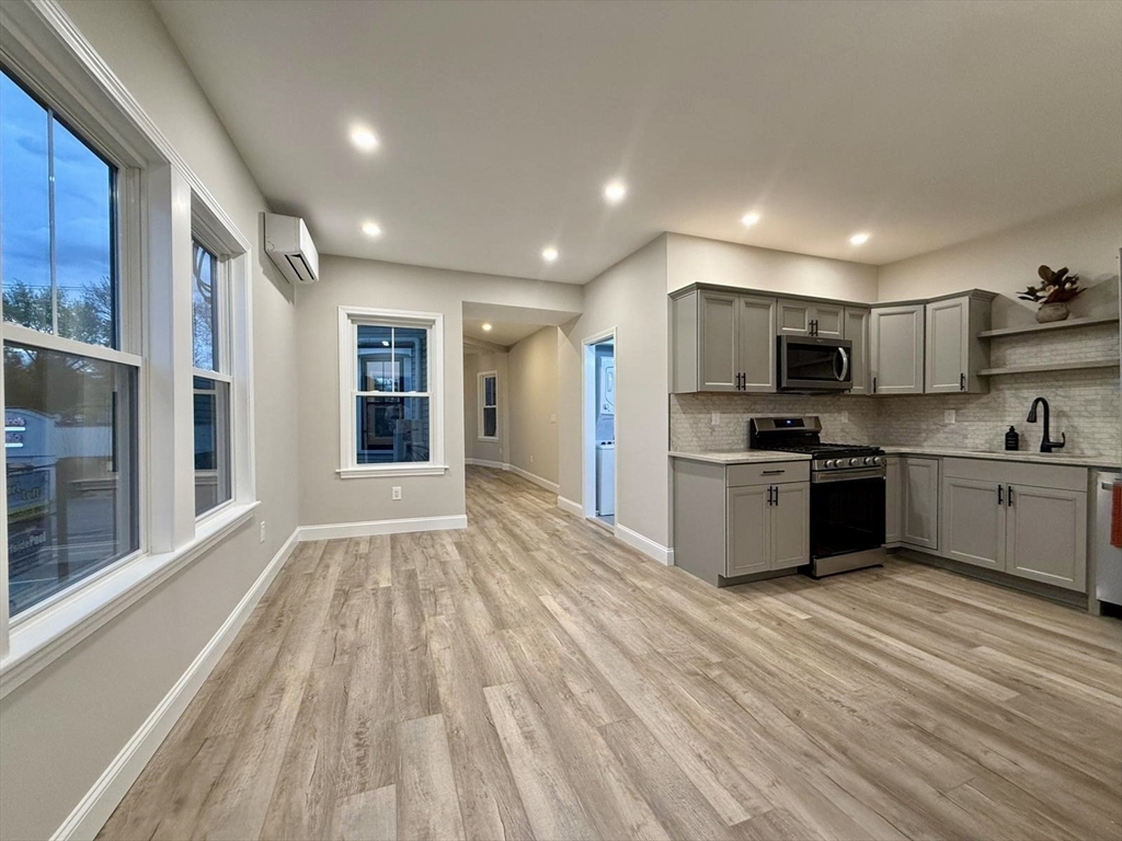 a kitchen with stainless steel appliances kitchen island granite countertop a refrigerator and a sink