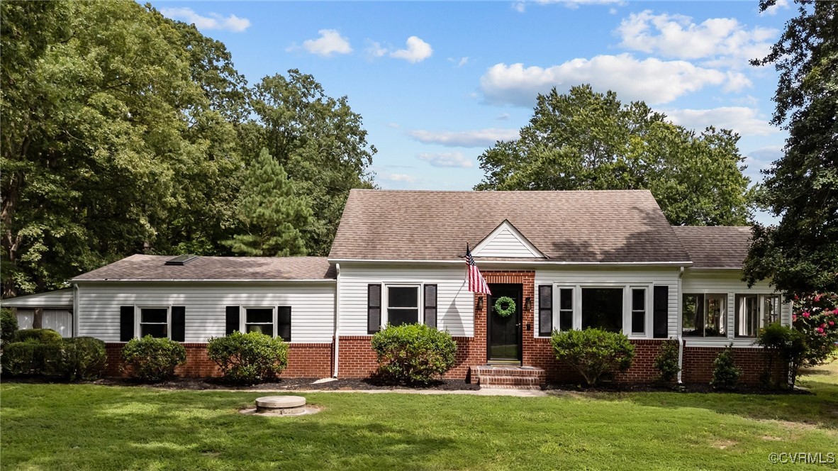 a front view of a house with a yard and potted plants