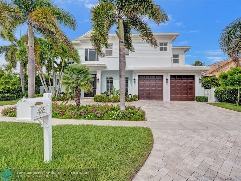 a front view of a house with a yard and palm trees