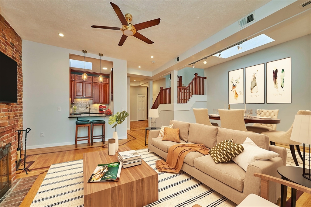 a living room with furniture kitchen view and a large window