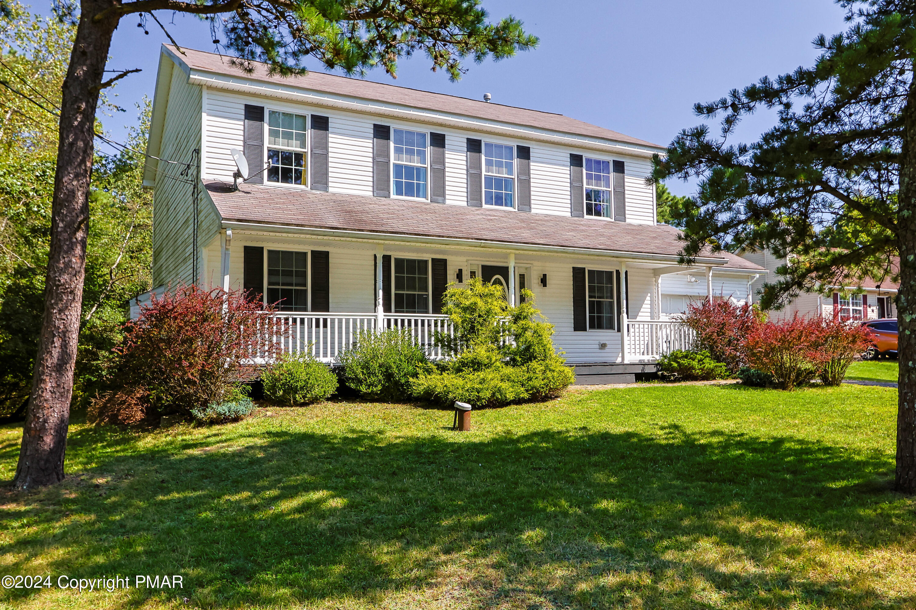 a front view of a house with a garden and yard