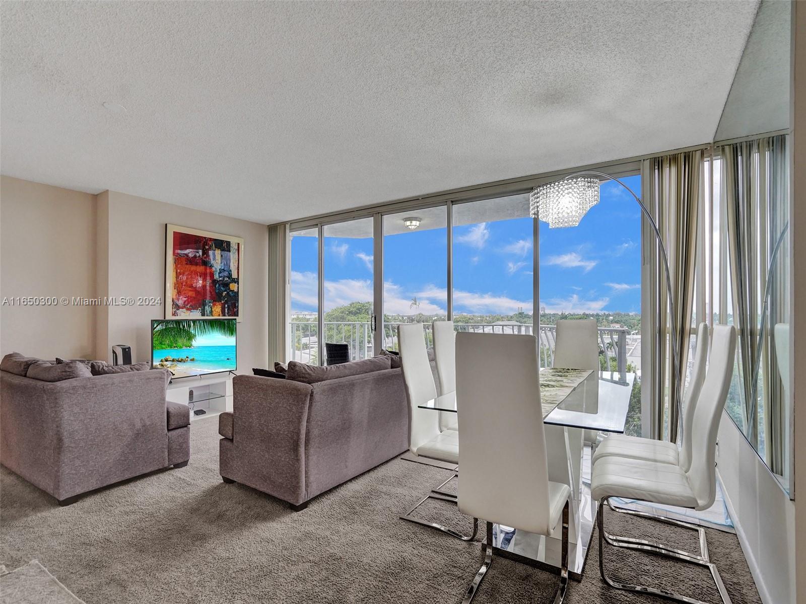 a living room with furniture and a floor to ceiling window