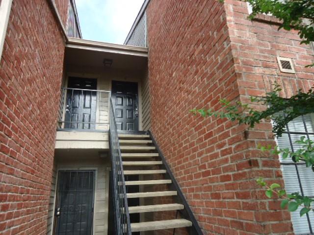 a view of a brick house with a large window and stairs