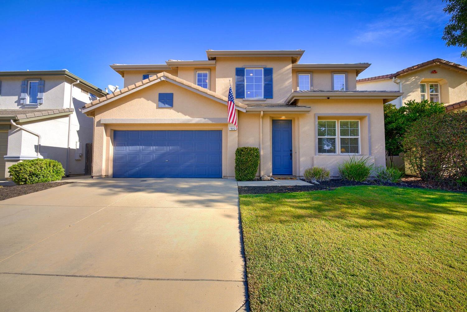 a front view of a house with yard and garage