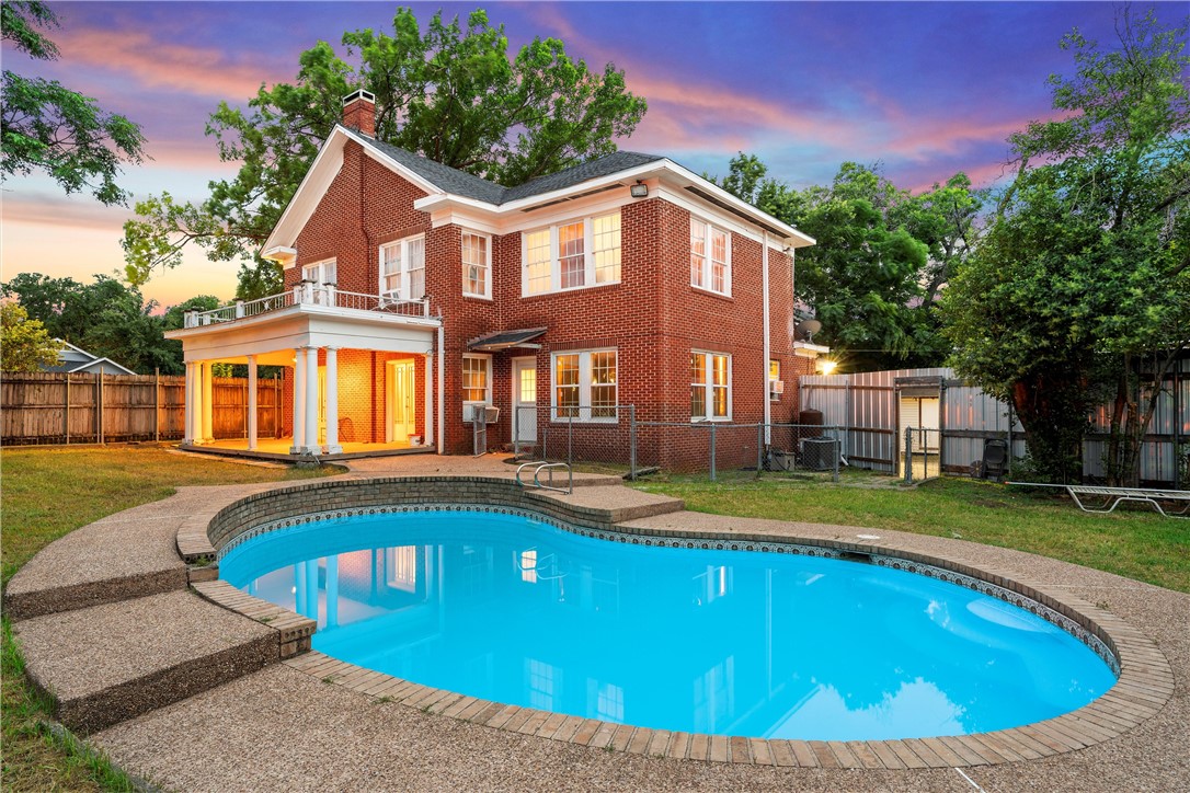 a view of an house with swimming pool and a yard