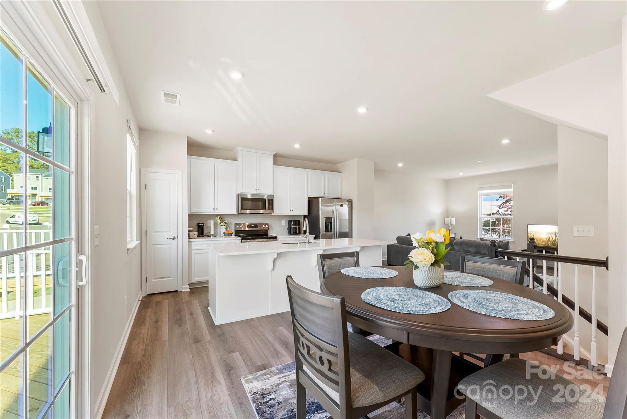 a kitchen with a dining table chairs and refrigerator