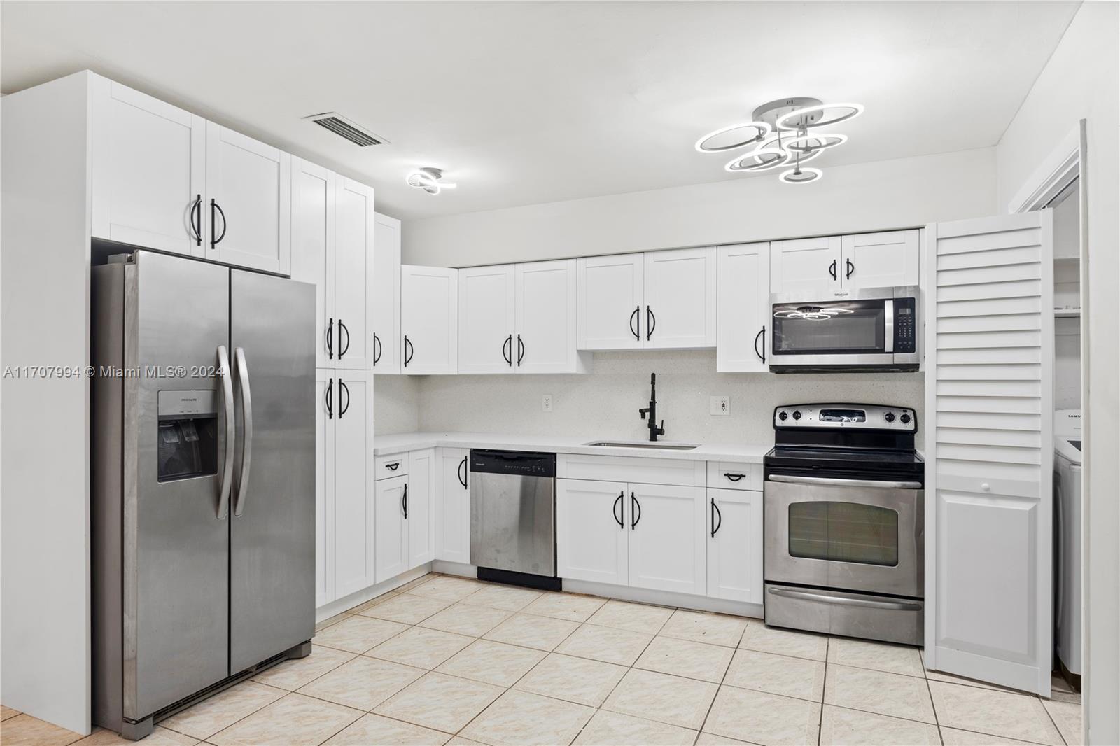 a kitchen with stainless steel appliances and white cabinets