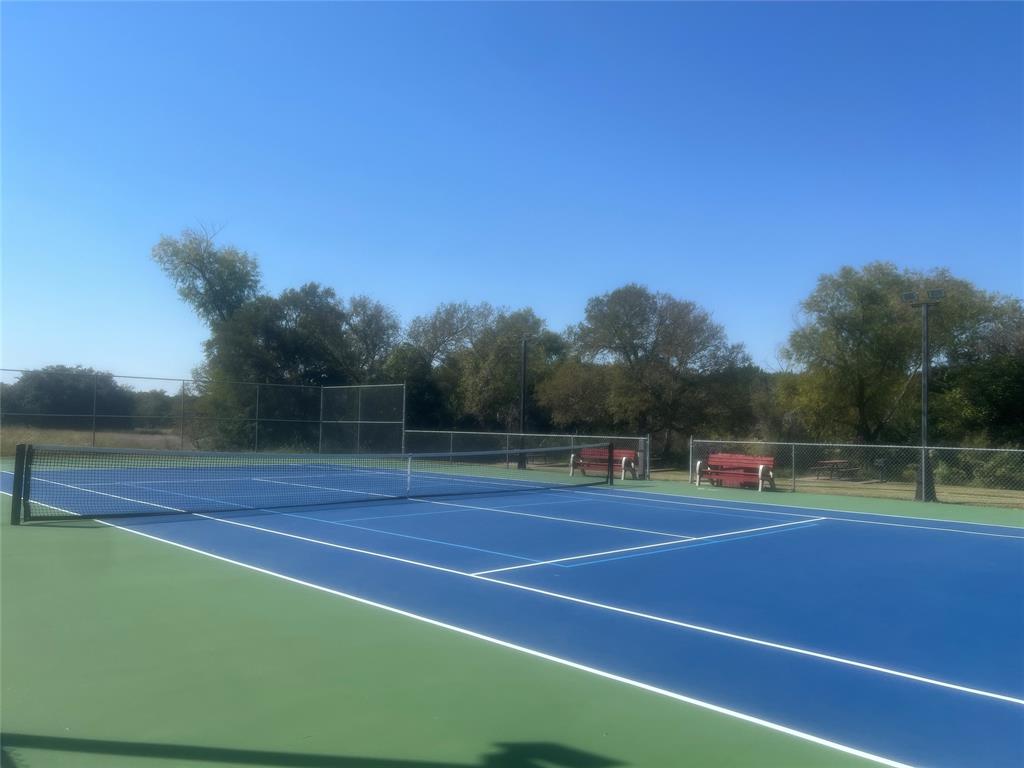 a view of tennis court with wooden fence