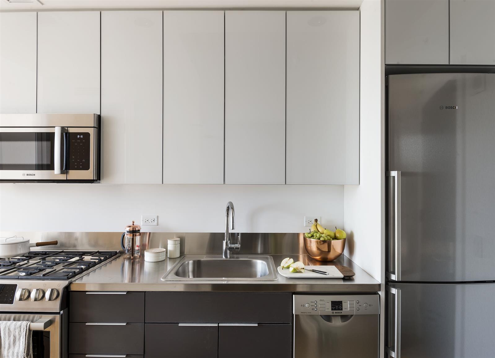 a kitchen with stainless steel appliances granite countertop a refrigerator sink and stove