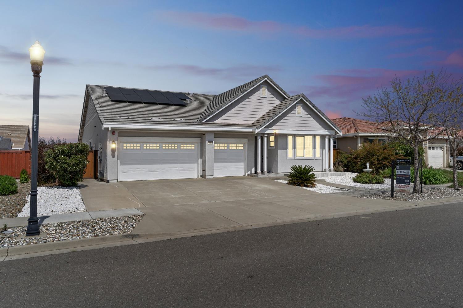 a front view of a house with a garden and garage