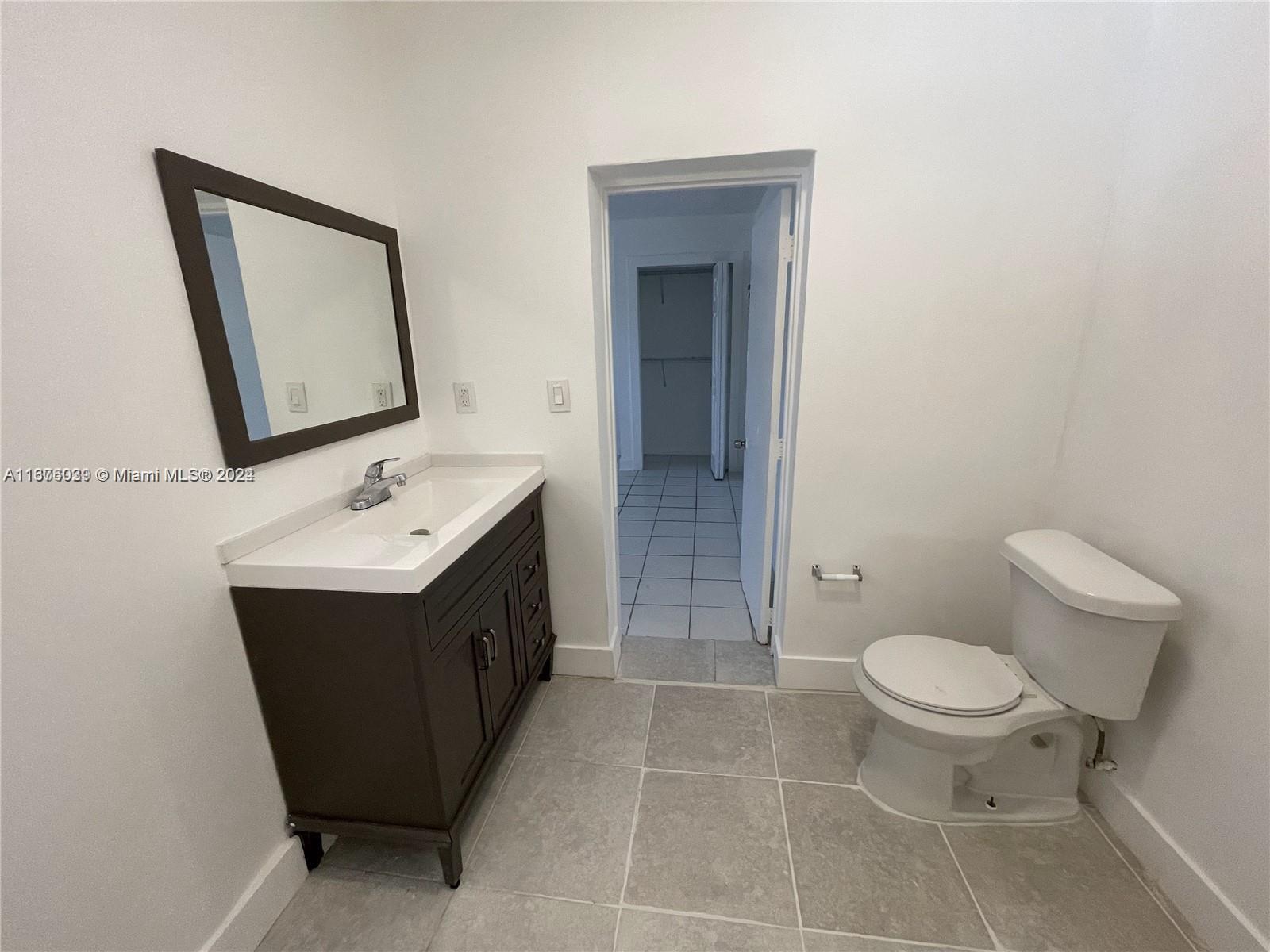 a bathroom with a sink vanity mirror and toilet