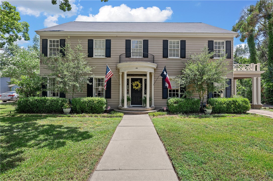 a front view of a house with yard and green space