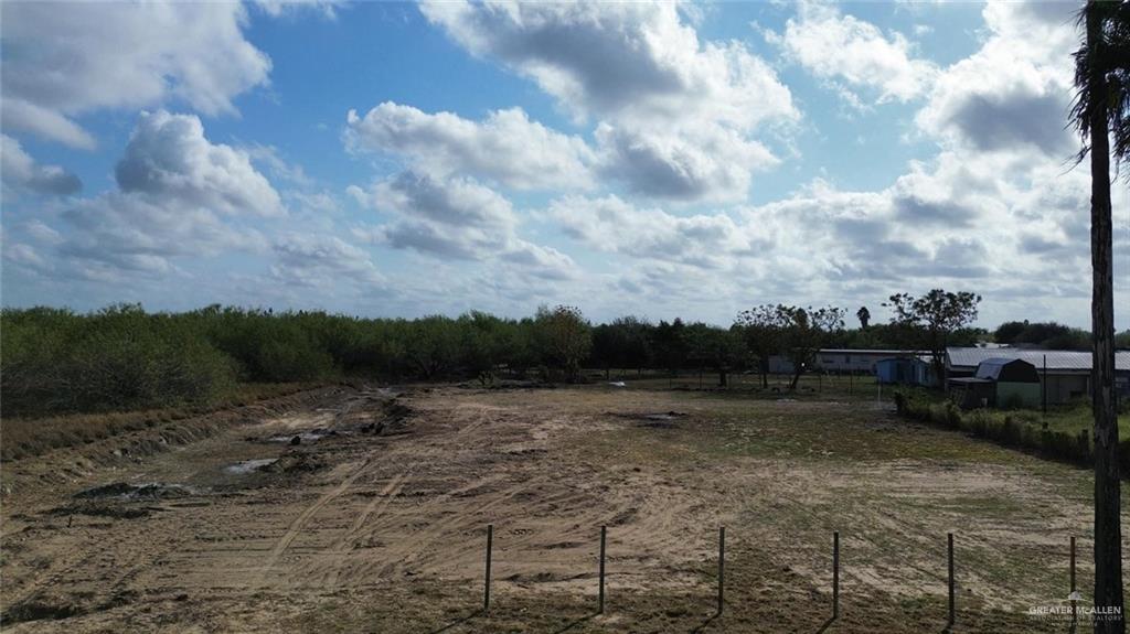 a view of a dry yard with wooden fence