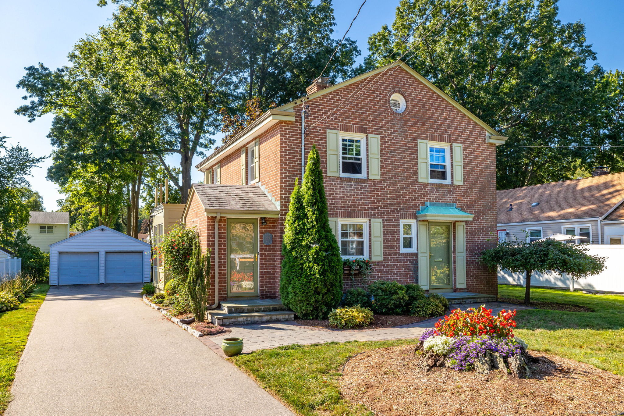 a front view of a house with a yard and potted plants