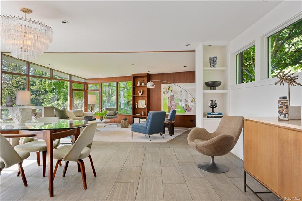 a living room with furniture a large window and wooden floor