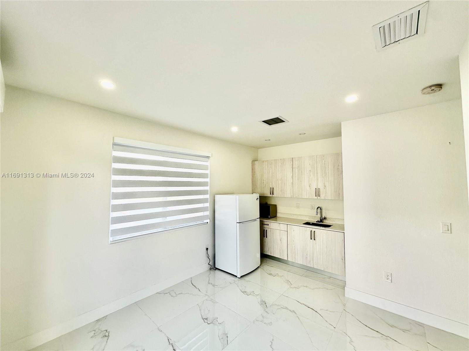 a view of a kitchen with a sink and a refrigerator