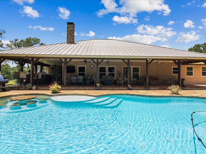 a view of a house with swimming pool and a yard