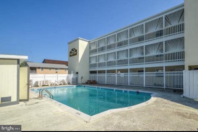 a view of a swimming pool with a chair and floor to ceiling window