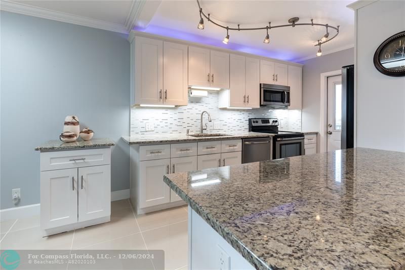 a kitchen with stainless steel appliances granite countertop a sink stove and refrigerator