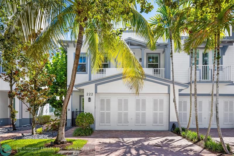 a view of a house with a yard and palm trees