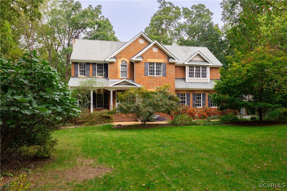 a front view of a house with a yard and green space