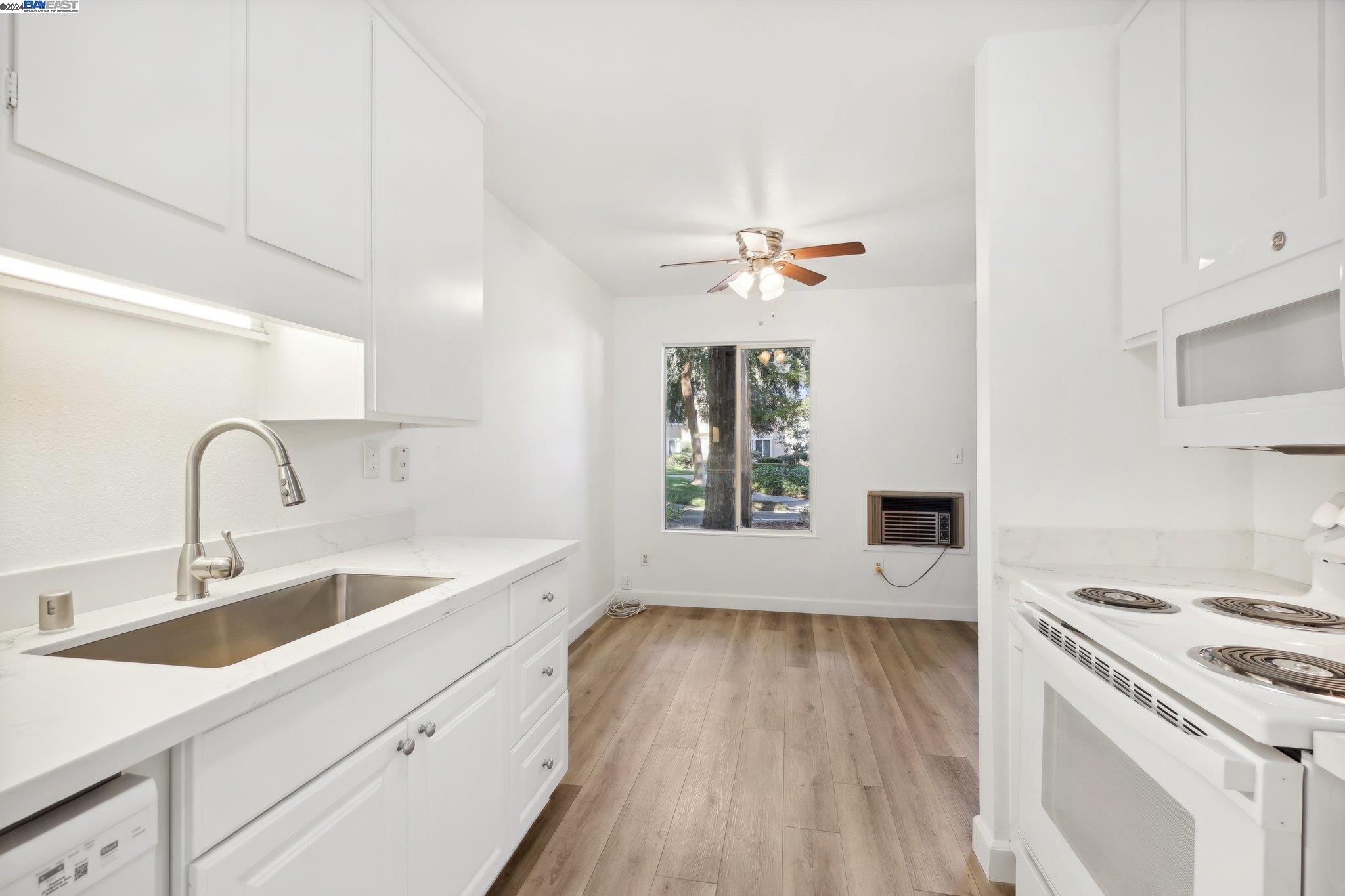 a view of a kitchen with a sink wooden floor and a window