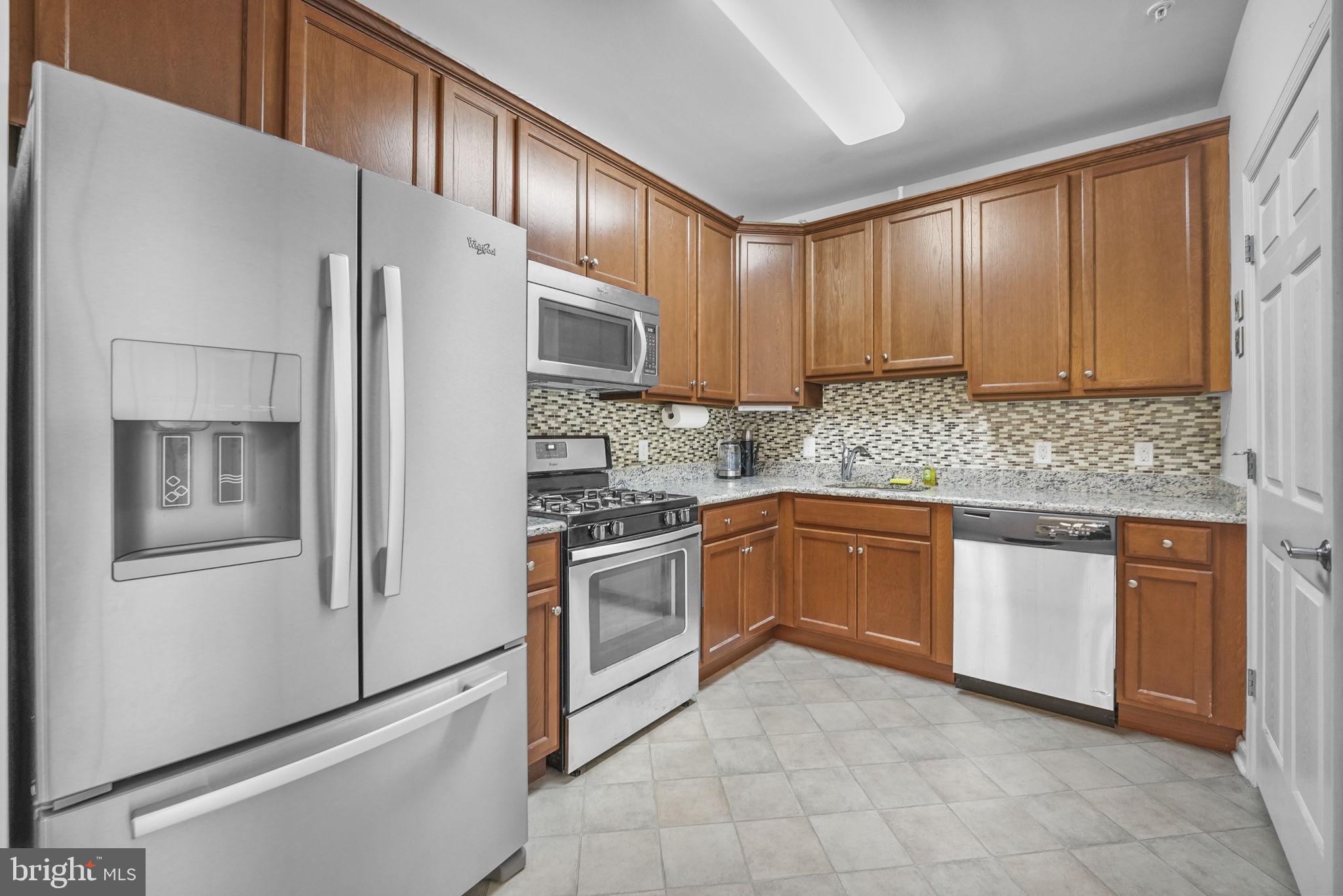 a kitchen with stainless steel appliances granite countertop a refrigerator sink and cabinets