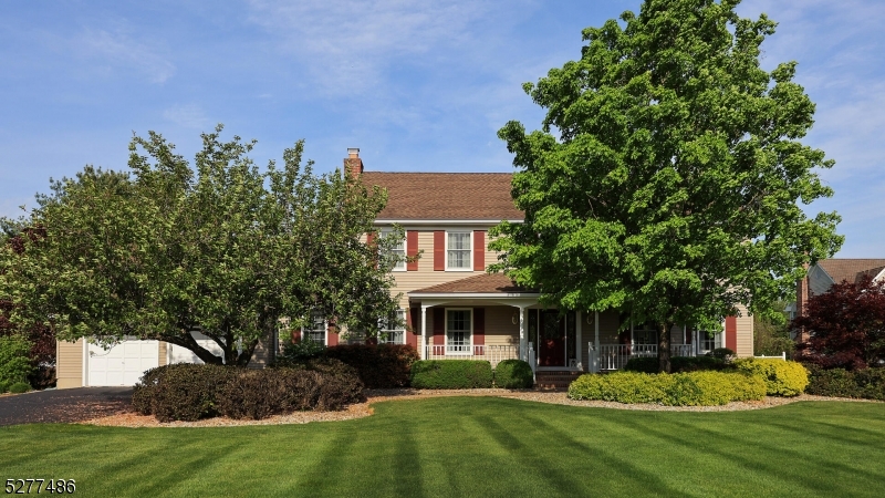 a front view of a house with a yard and trees