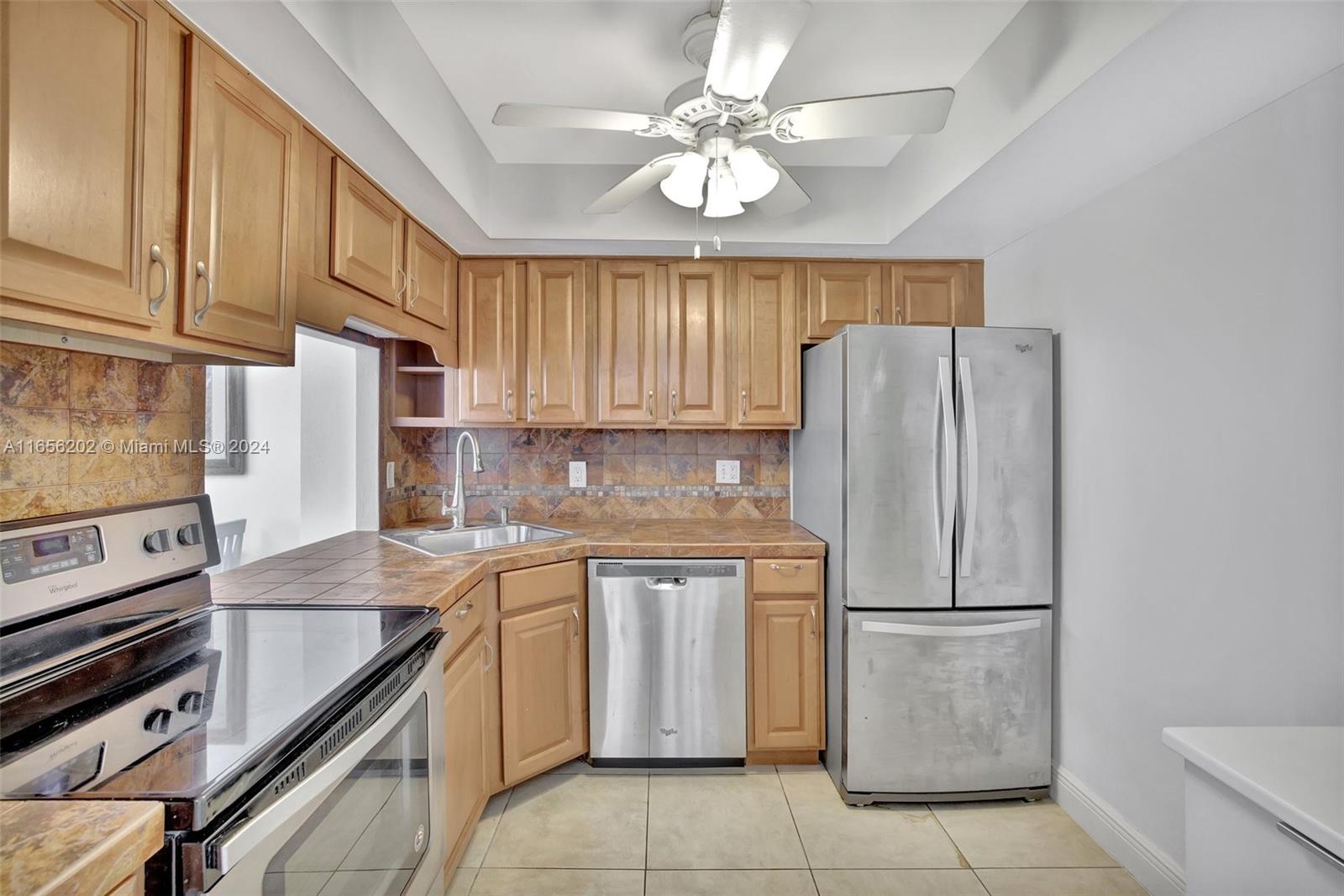 a kitchen with a sink a refrigerator and a stove