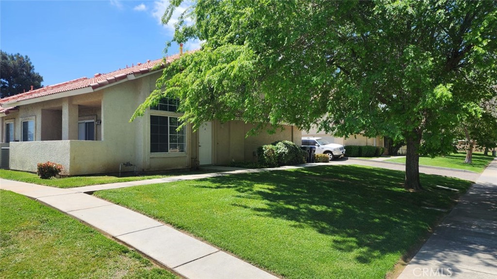 a front view of a house with a yard and trees