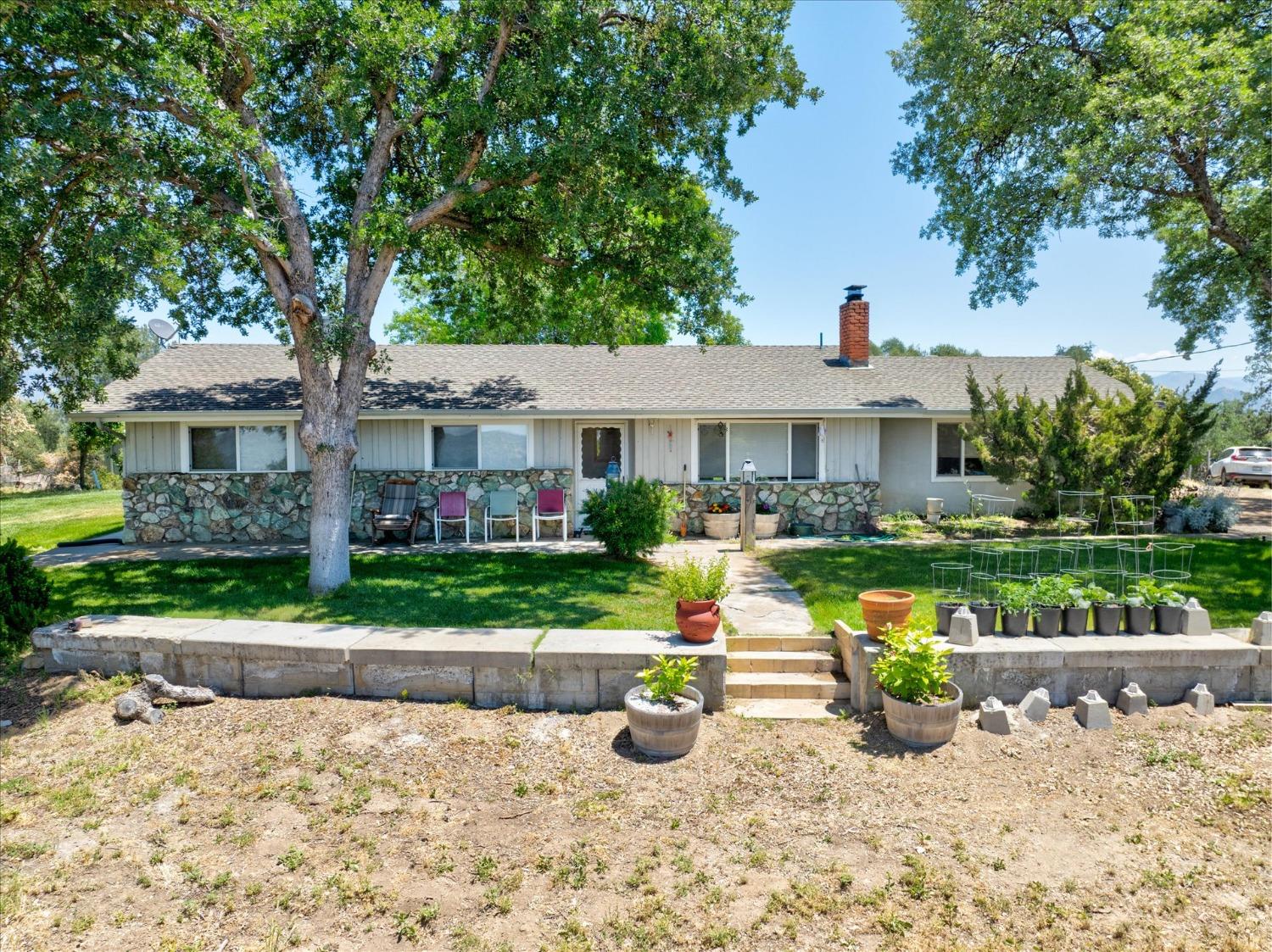 a front view of a house with a yard and potted plants